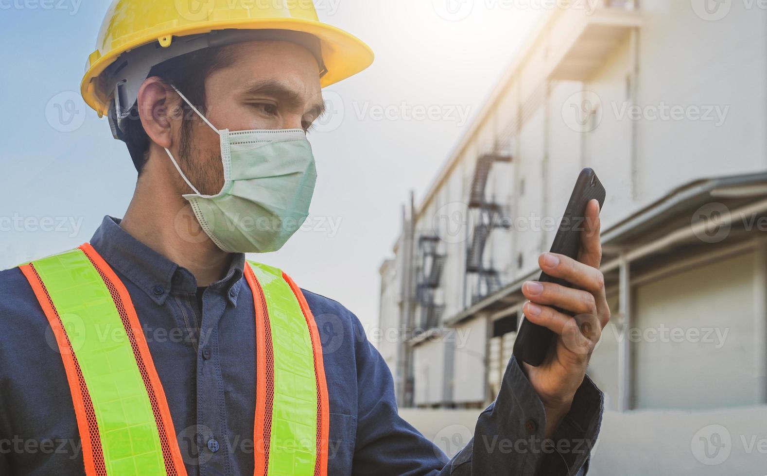 ingeniero sosteniendo teléfono inteligente enviar mensaje tecnología de internet, ingeniero construcción inspección proyecto de construcción foto