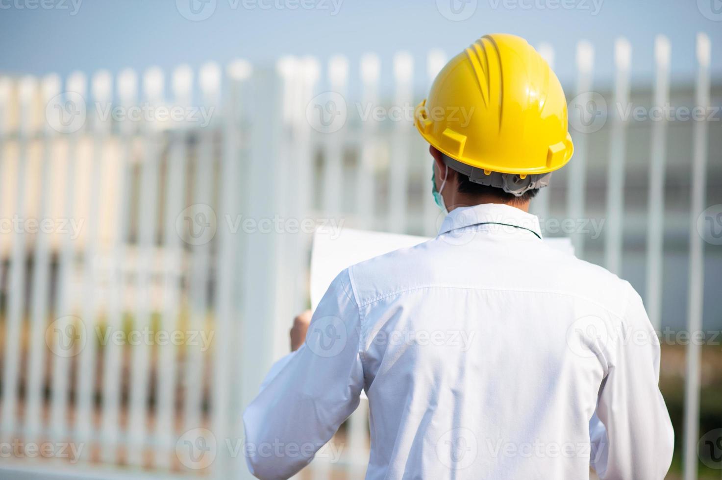 Engineer hold paper work or blueprint and survey on site construction photo