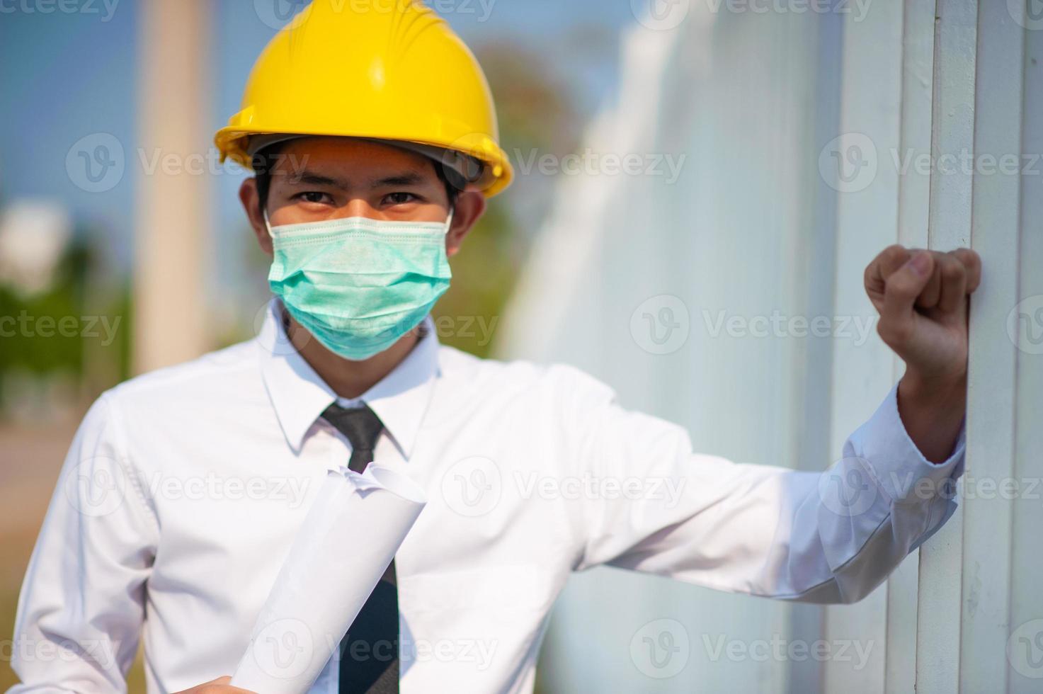 El ingeniero mantiene el papeleo o el plano y la encuesta sobre la construcción del sitio. foto