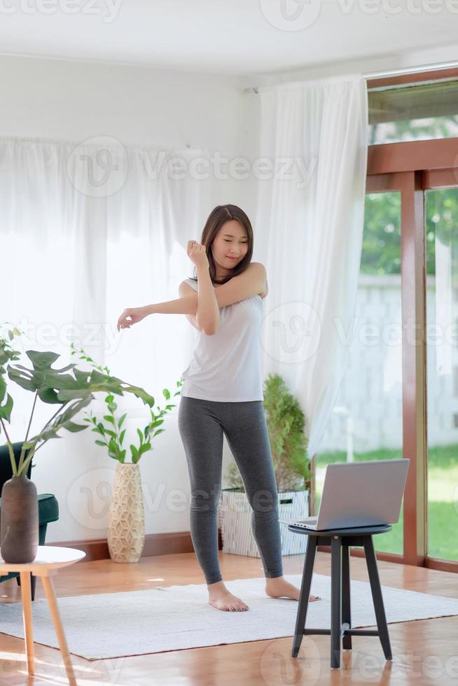 Beautiful asian woman staying fit by exercising at home for healthy trend lifestyle photo