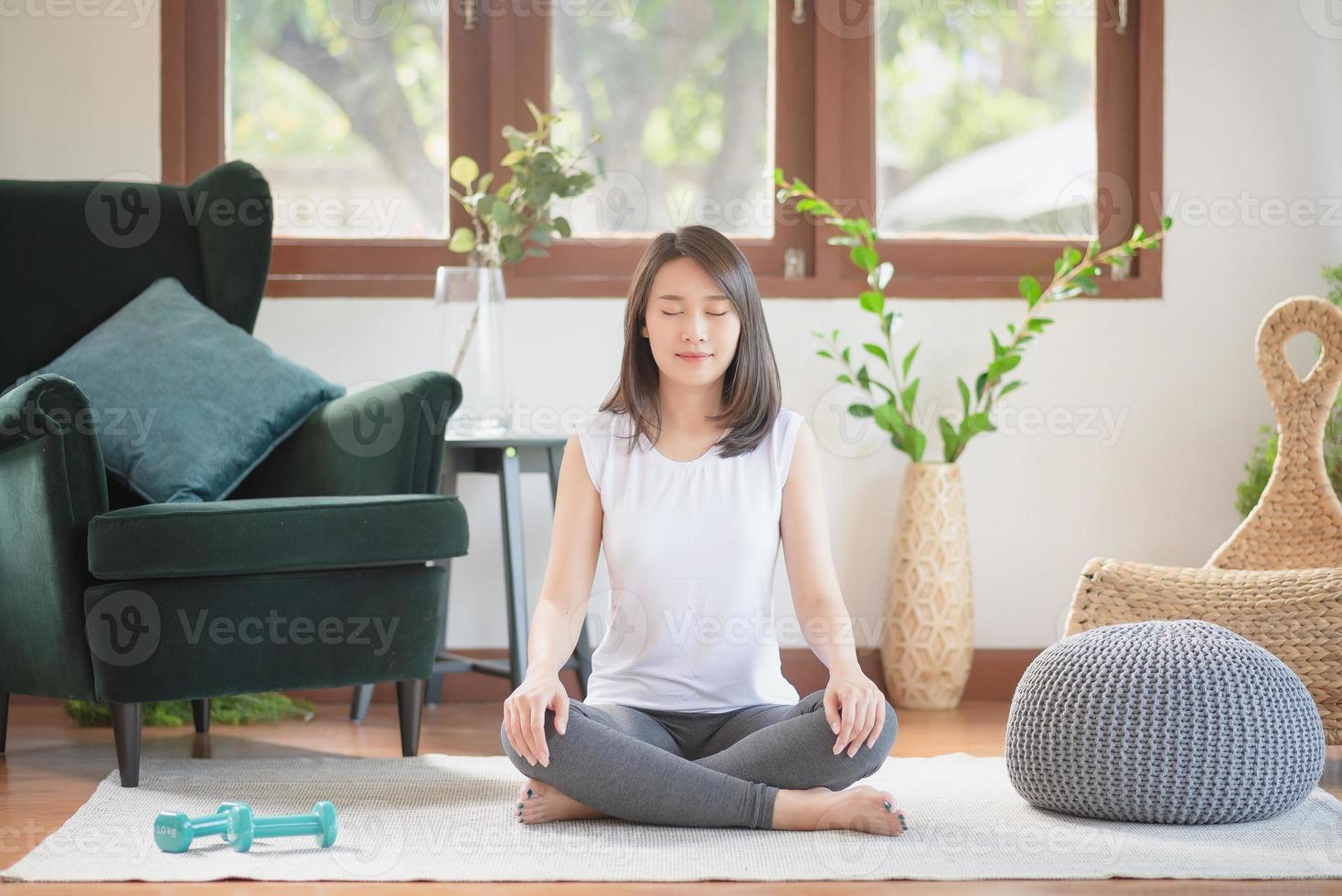 Hermosa mujer asiática mantenerse en forma haciendo ejercicio en casa para un estilo de vida saludable foto