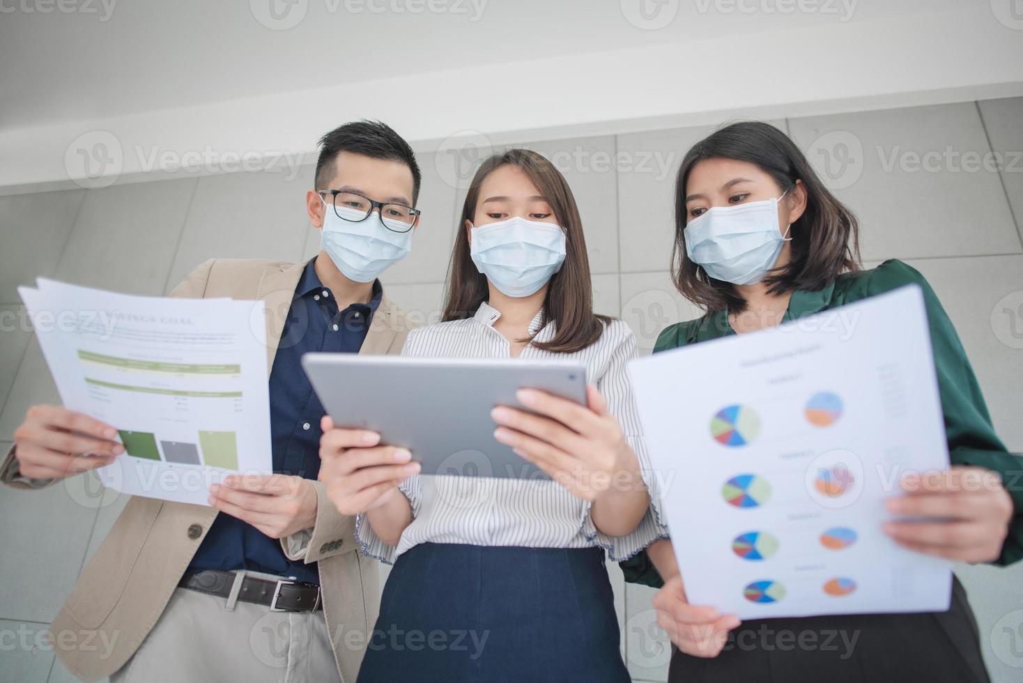 Empleados comerciales que usan máscara durante el trabajo en la oficina para mantener la higiene y seguir la política de la empresa. Prevención durante el período de epidemia de coronavirus o covid19. foto