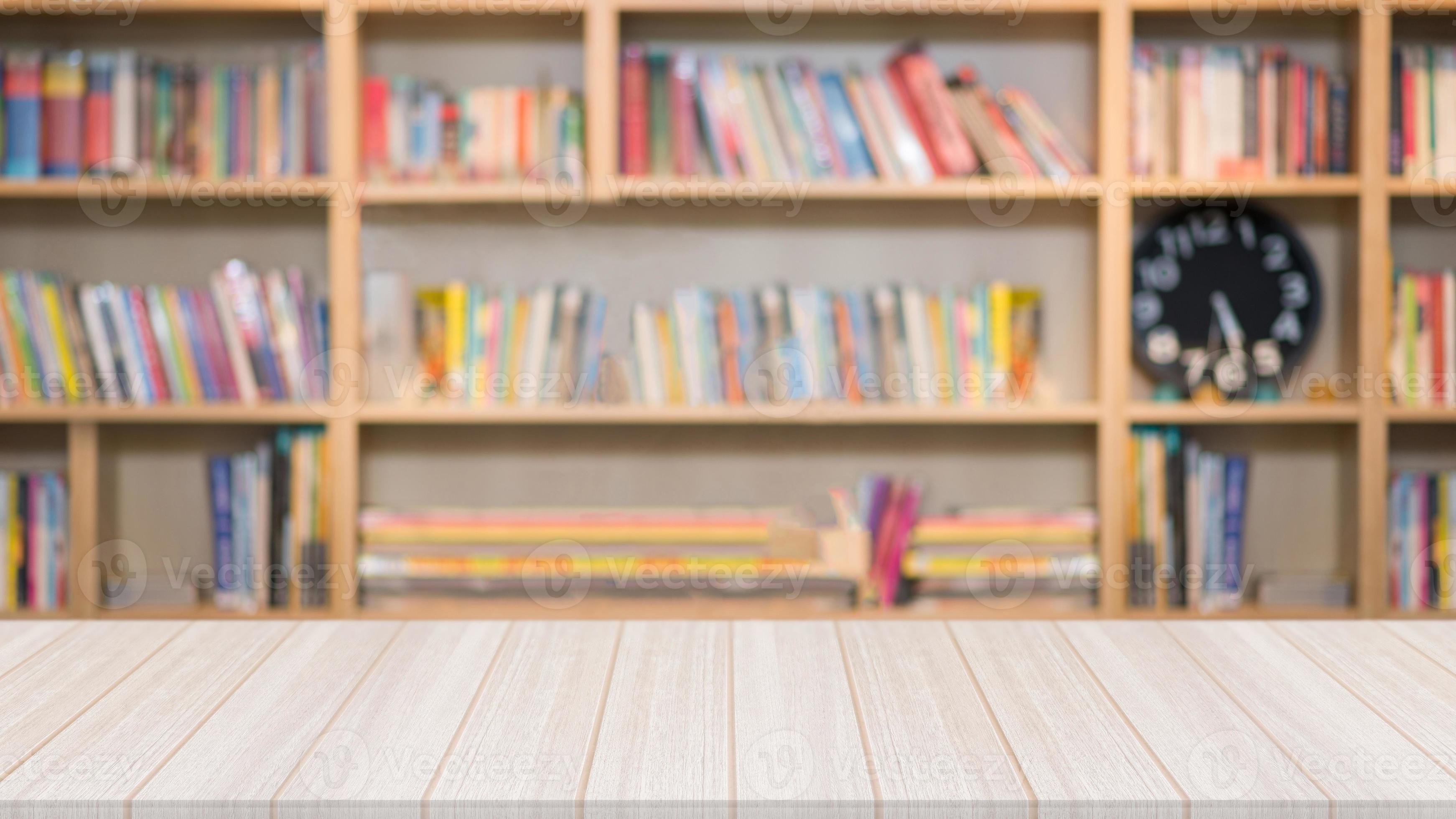Wooden table in the library with a blurred bookshelf with many book in
