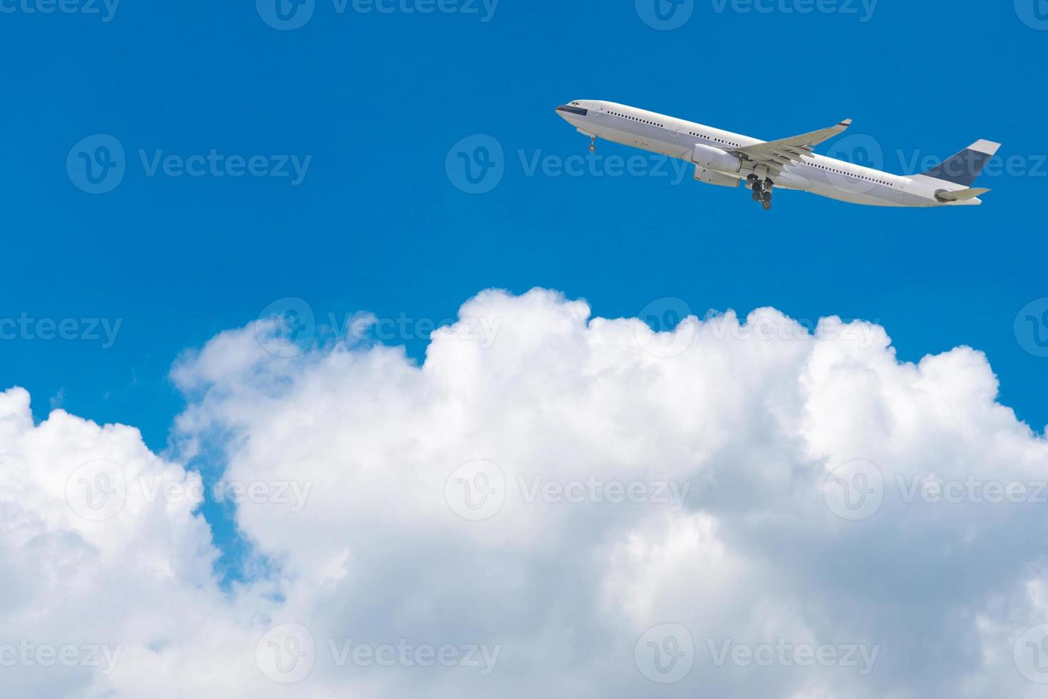 Commercial airplane flying over bright blue sky and white clouds. Elegant Design with copy space for travel concept. photo