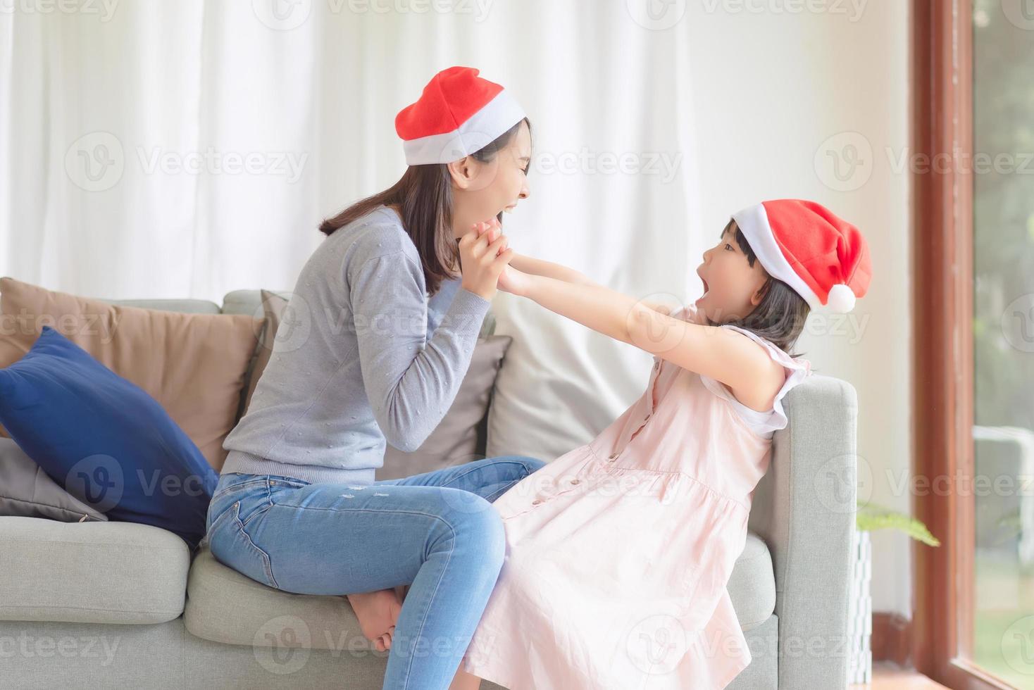 madre e hija asiáticas disfrutan de celebrar la fiesta de navidad y año nuevo en casa en diciembre foto