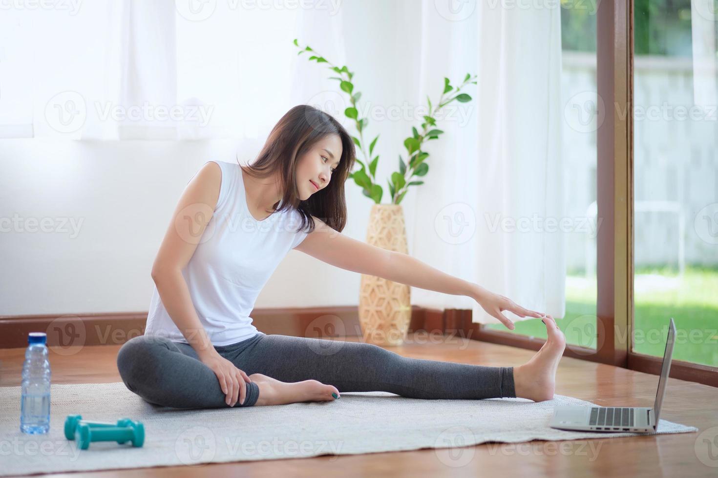 Hermosa mujer asiática mantenerse en forma haciendo ejercicio en casa para un estilo de vida saludable foto