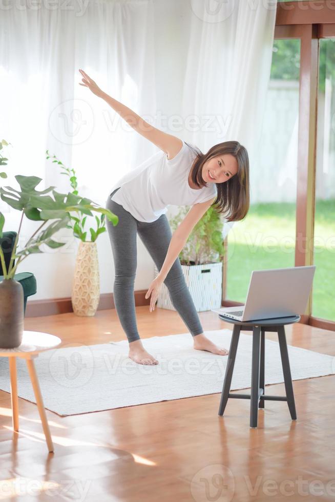 Hermosa mujer asiática mantenerse en forma haciendo ejercicio en casa para un estilo de vida saludable foto