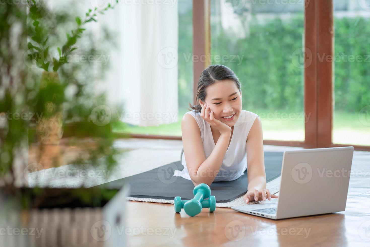 Beautiful asian woman staying fit by exercising at home for healthy trend lifestyle photo