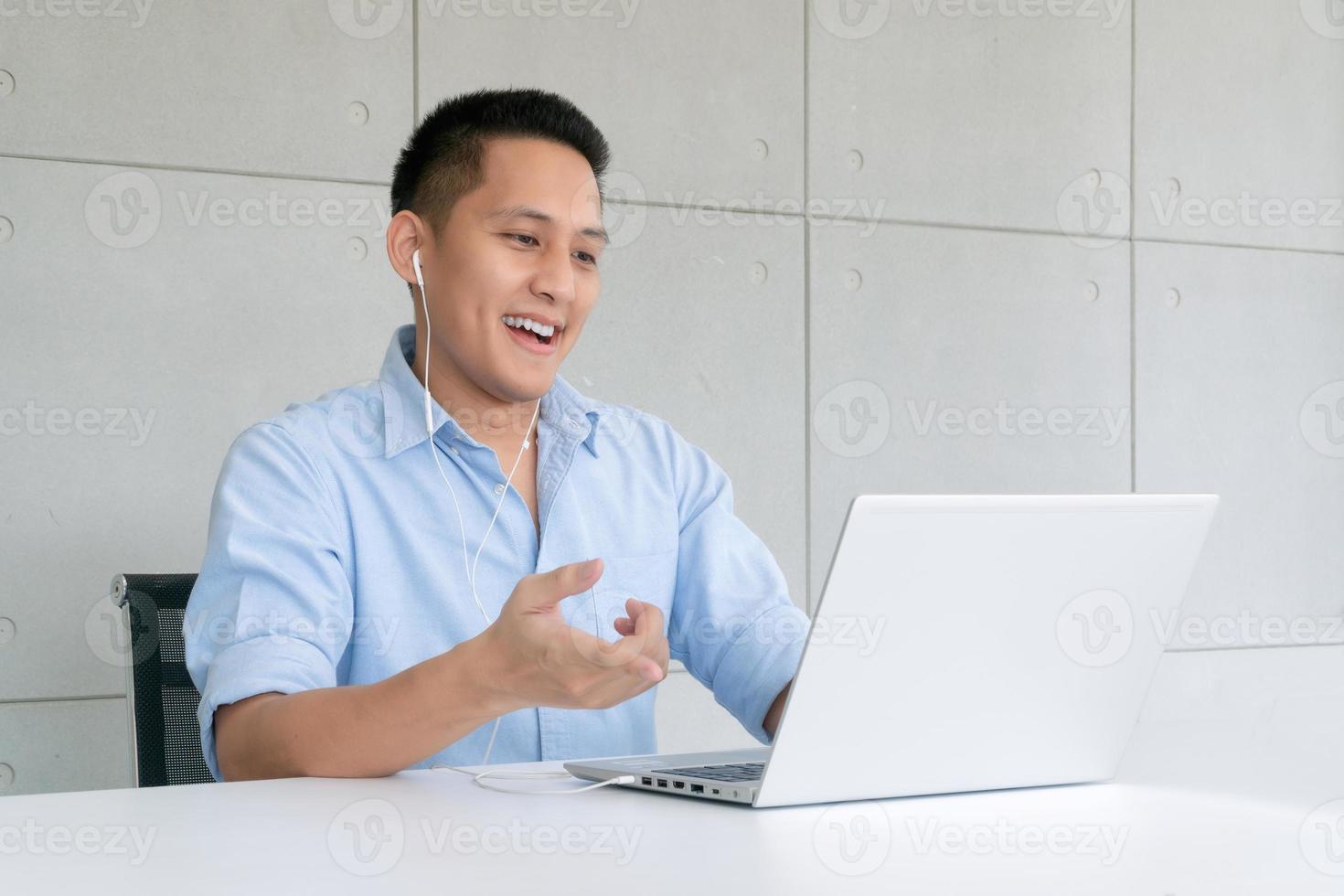 Hombre de negocios que usa una computadora portátil para realizar videoconferencias con colegas a través de la tecnología de Internet en la oficina en casa. preventivo durante el período de epidemia de coronavirus o covid19. foto