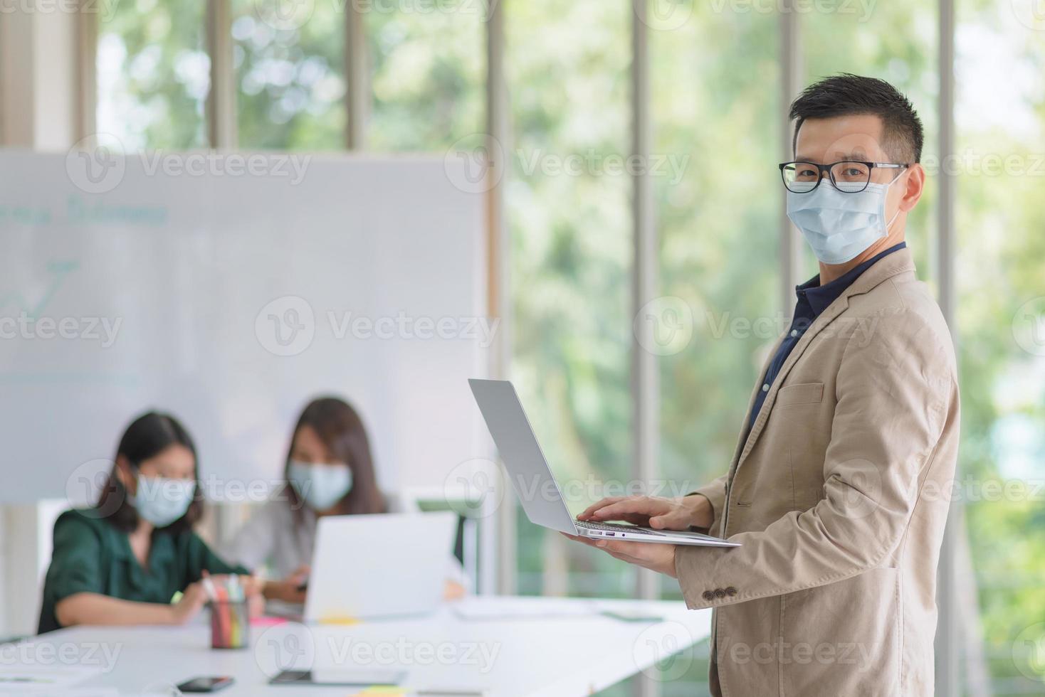 Empleados comerciales que usan máscara durante el trabajo en la oficina para mantener la higiene y seguir la política de la empresa. Prevención durante el período de epidemia de coronavirus o covid19. foto