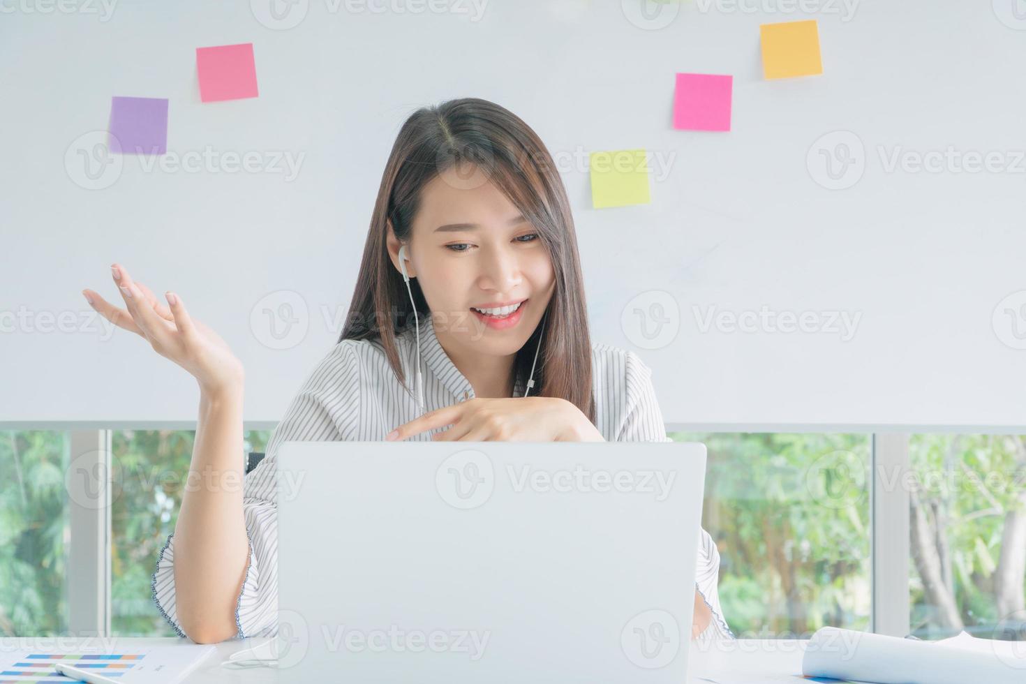 mujer de negocios que usa una computadora portátil para realizar videoconferencias con colegas a través de la tecnología de Internet en la oficina. preventivo durante el período de epidemia de coronavirus o covid19. foto