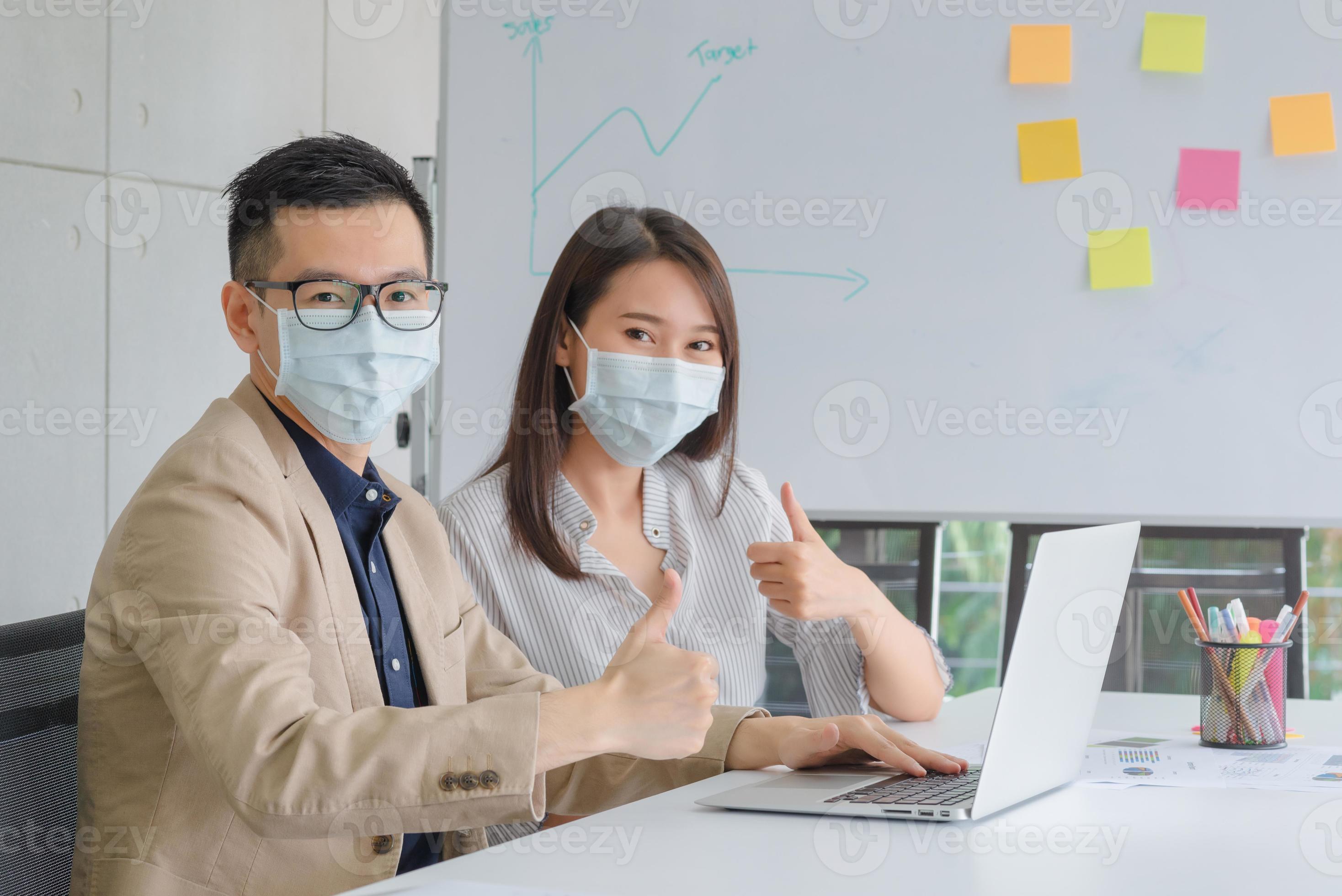 Business employees wearing mask during work in office to keep hygiene