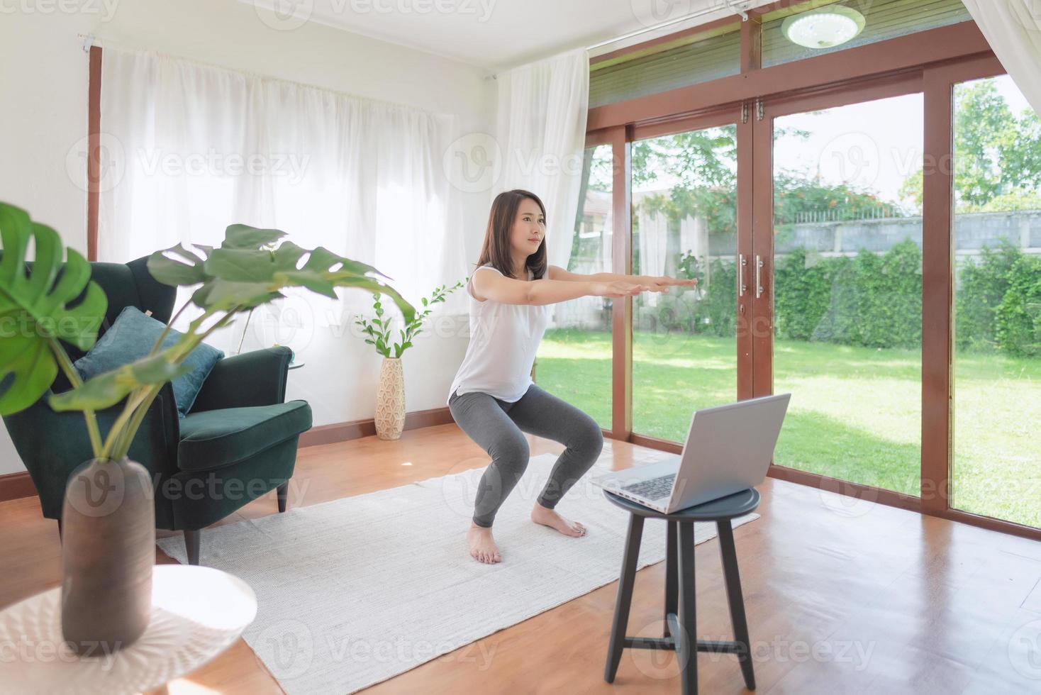 Beautiful asian woman staying fit by exercising at home for healthy trend lifestyle photo
