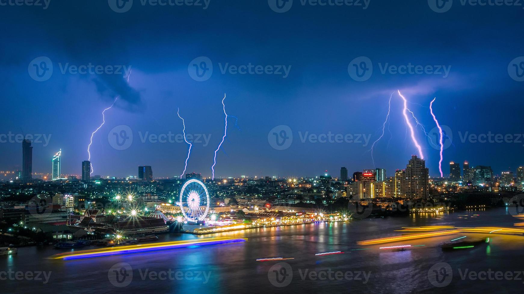 Thunder storm lightning strike on the dark cloudy sky over business building area in Bangkok,Thailand. Bangkok is the capital of Thailand and also the most populated city. photo