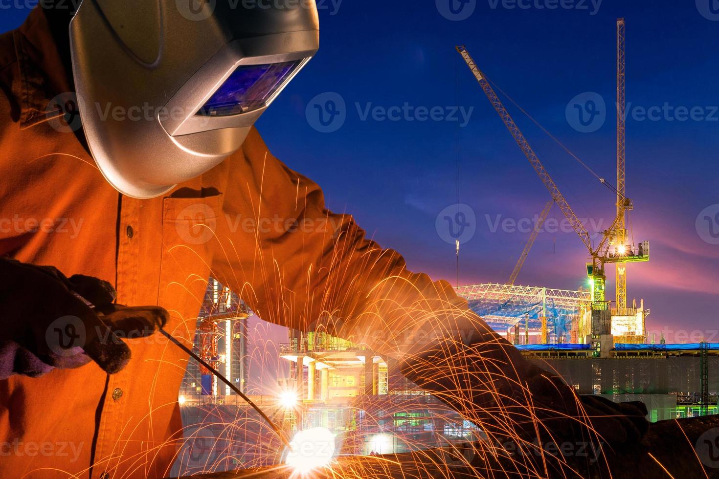 Industrial worker welding steel structure for infrastructure building project with construction site background. photo