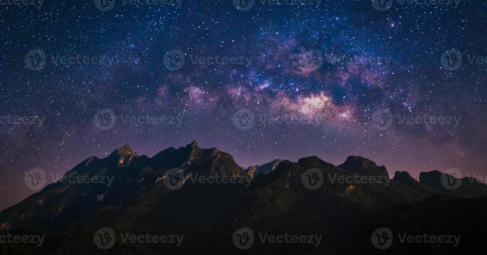 Night view of nature mountain with universe space of milky way galaxy and stars on sky photo