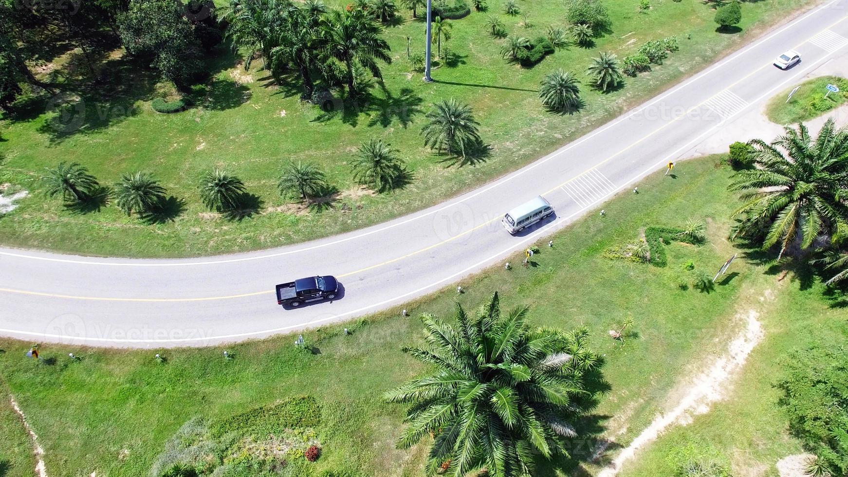 La vista aérea desde el avión no tripulado de los coches atraviesa una carretera curva en la montaña con bosque verde. el camino del transporte a través de la montaña. foto