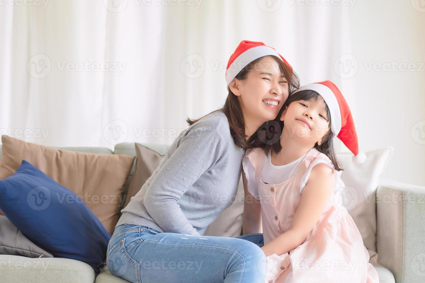 madre e hija asiáticas disfrutan de celebrar la fiesta de navidad y año nuevo en casa en diciembre foto