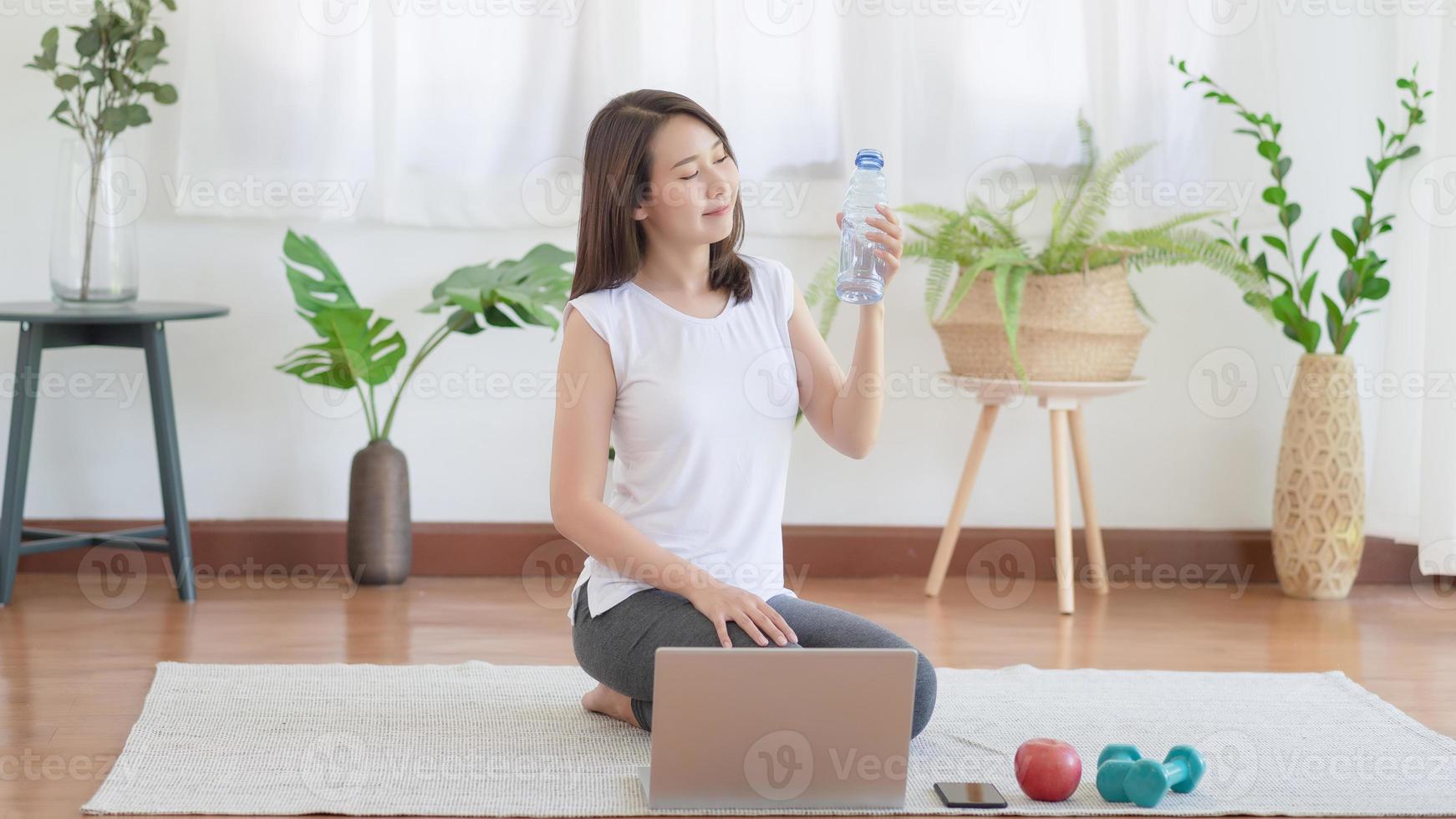 Beautiful asian woman staying fit by exercising at home for healthy trend lifestyle photo