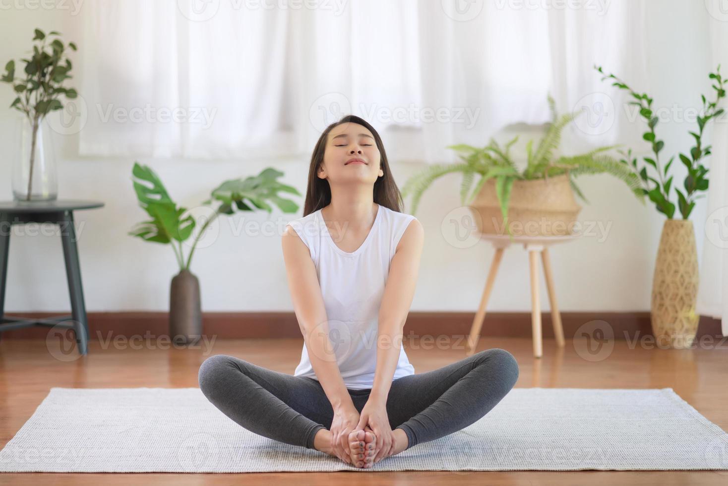 Hermosa mujer asiática mantenerse en forma haciendo ejercicio en casa para un estilo de vida saludable foto