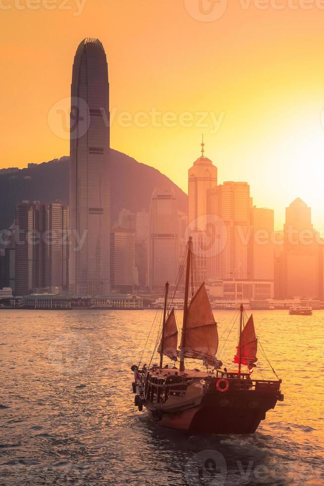 Barco de turistas tradicionales de Hong Kong para el servicio turístico en el puerto de Victoria con vistas a la ciudad de fondo al atardecer, vista desde el lado de Kowloon en Hong Kong foto