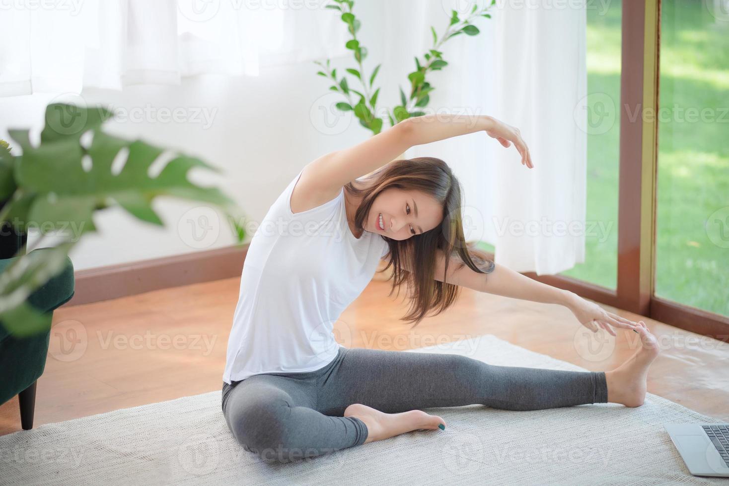 Hermosa mujer asiática mantenerse en forma haciendo ejercicio en casa para un estilo de vida saludable foto