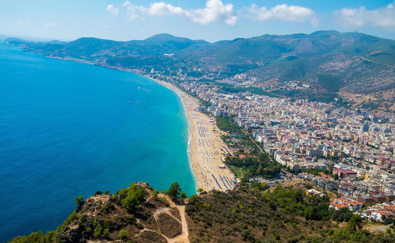 Vista superior de la playa de Alanya en la montaña Castillo de Alanya con ferry de la costa en el mar azul y el fondo de la ciudad portuaria - Hermosa playa de Cleopatra Paisaje de alanya Turquía Hito de viaje foto