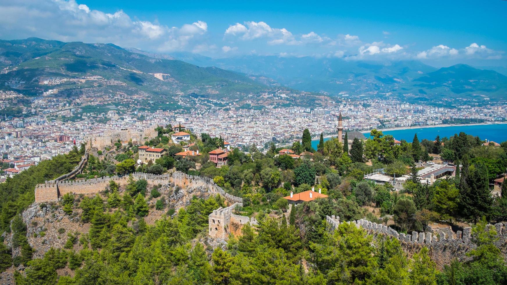 Alanya beach top view on the mountain alanya castle with coast ferry boat on blue sea and harbor city background - Beautiful cleopatra beach Alanya Turkey landscape travel landmark photo