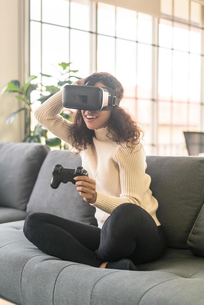 Latin woman using a virtual reality headset on sofa photo