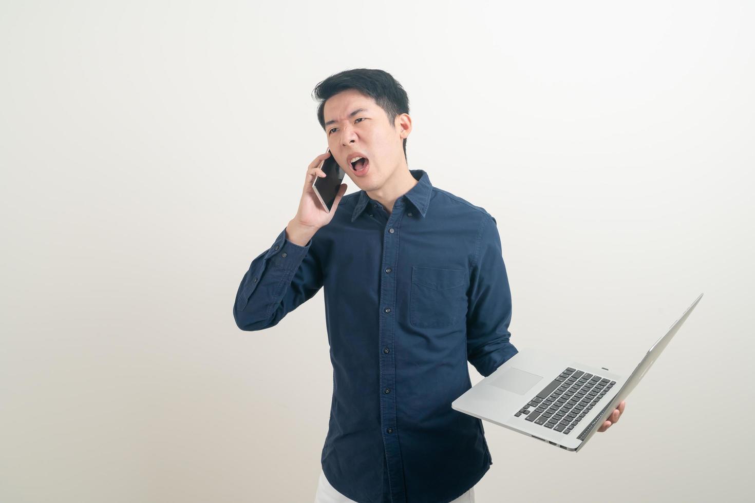 Asian man talking smartphone or mobile phone and hand holding laptop photo