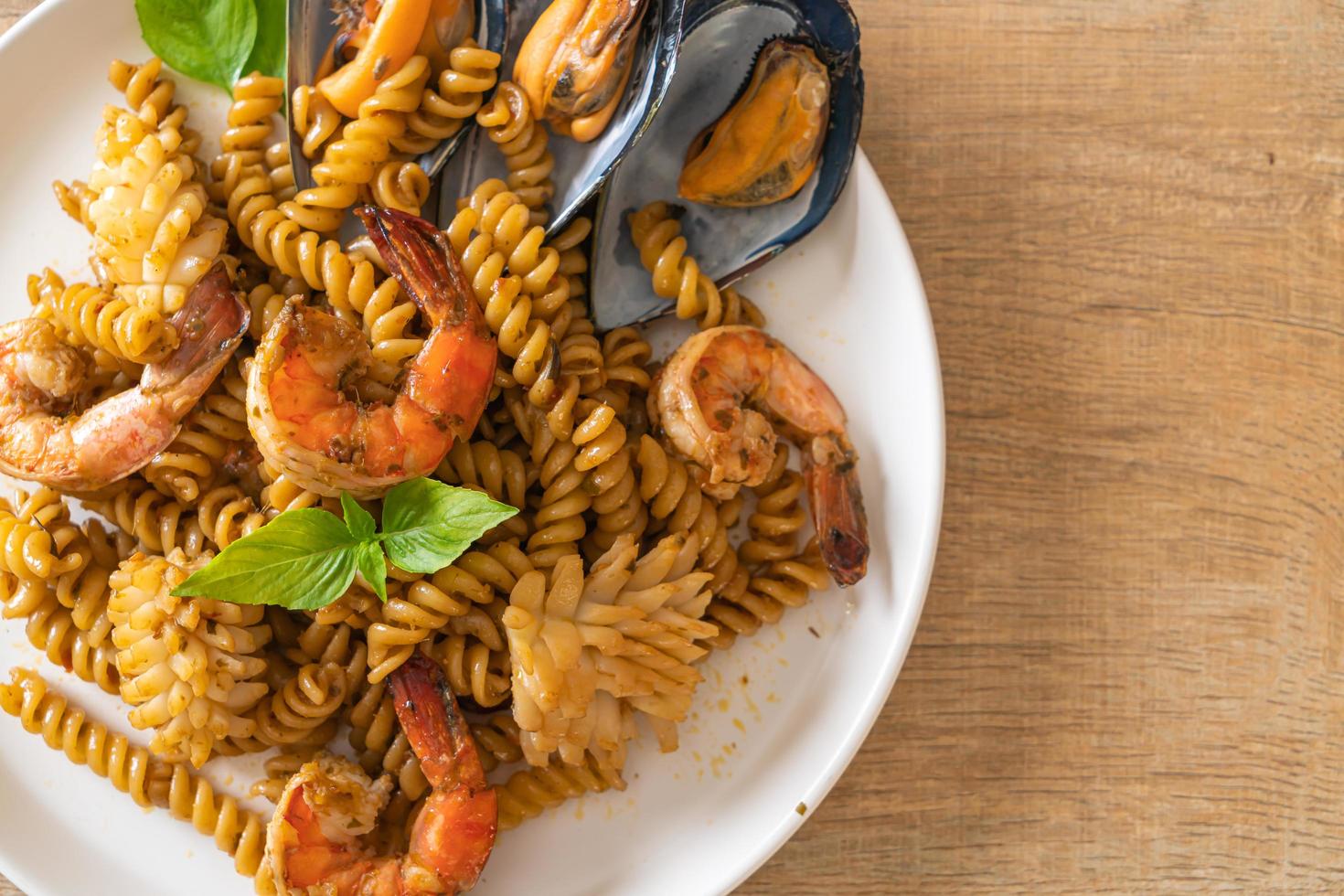 stir-fried spiral pasta with seafood and basil sauce photo
