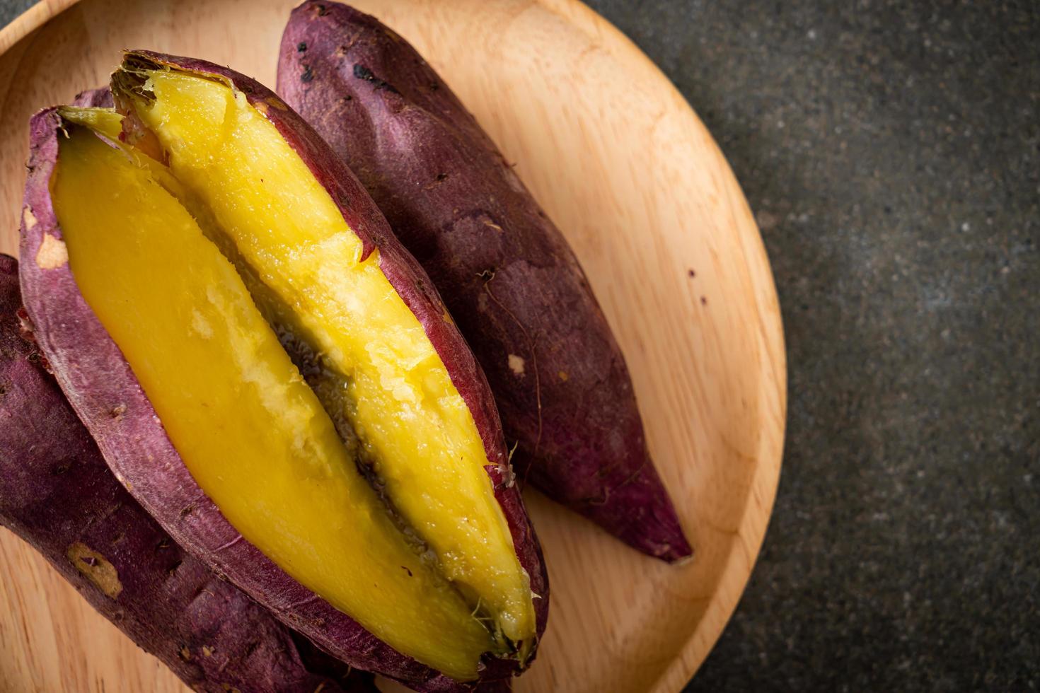 Grilled or baked Japanese sweet potatoes on wood plate photo