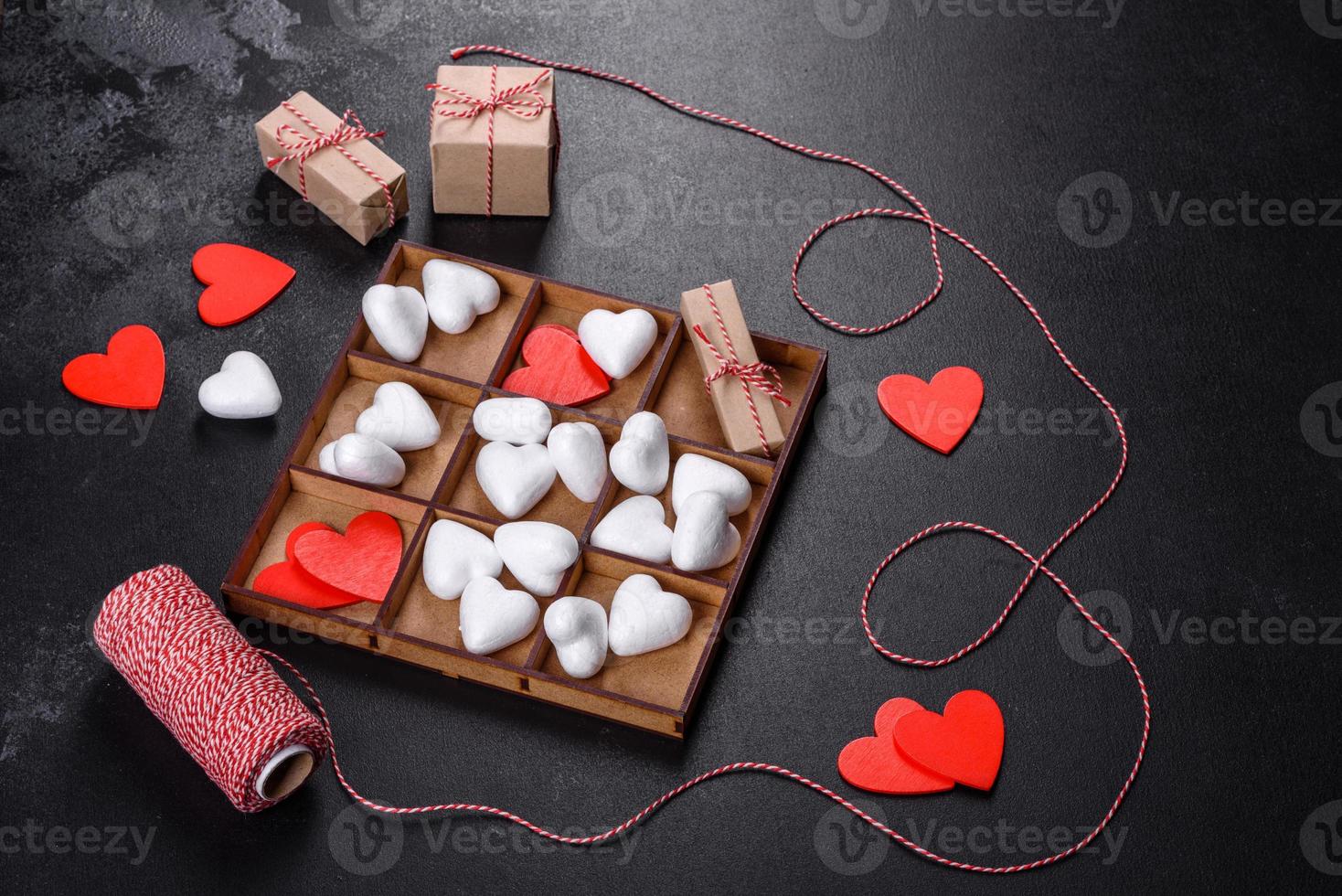 hermoso fondo con corazones blancos y rojos sobre una mesa oscura foto