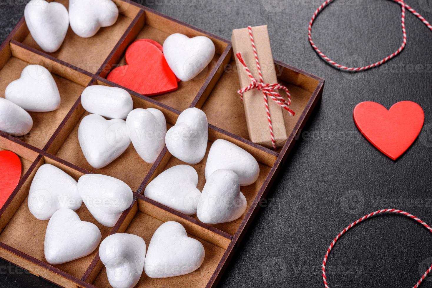 hermoso fondo con corazones blancos y rojos sobre una mesa oscura foto