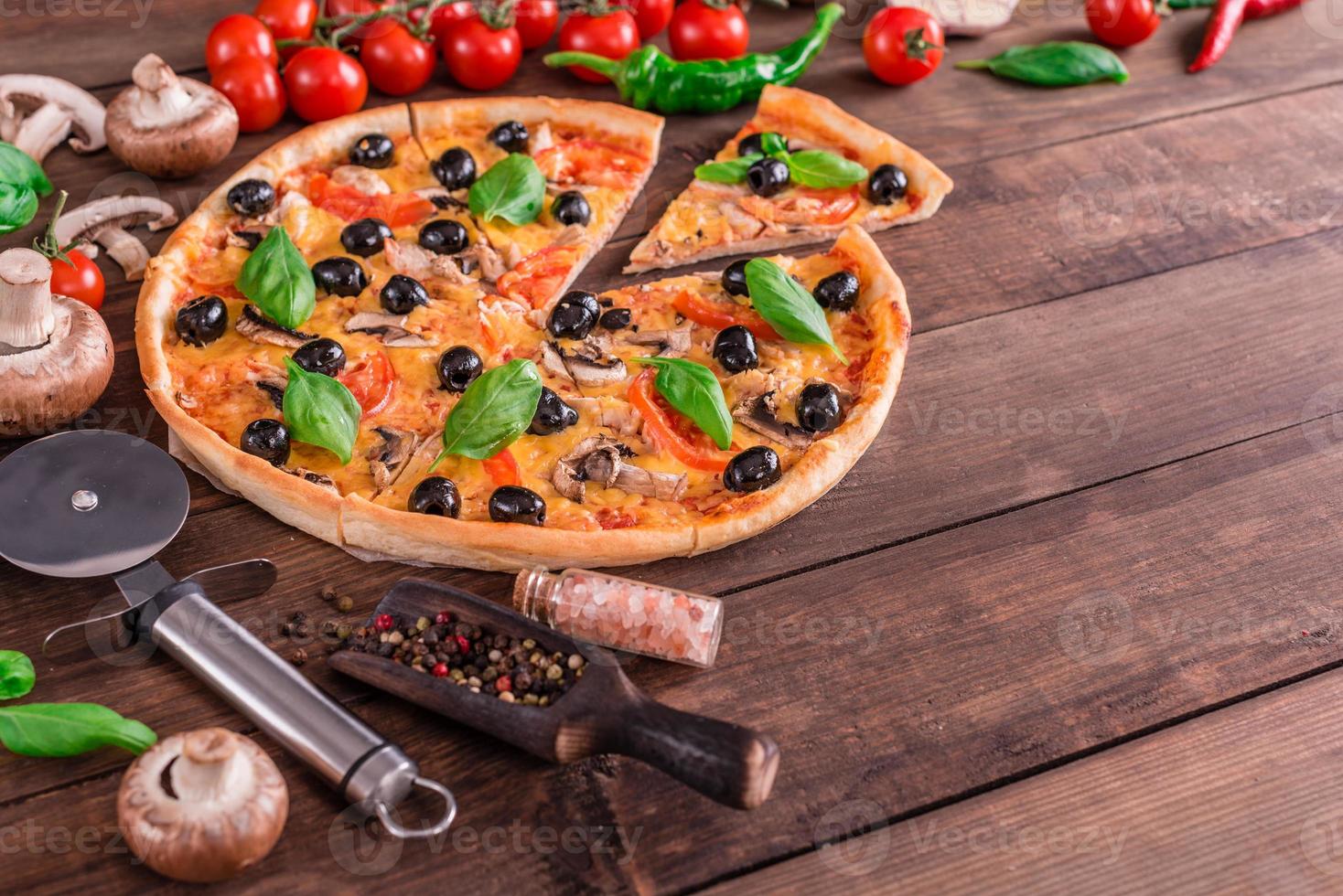 Delicious pizza with olives and chicken on wooden table photo