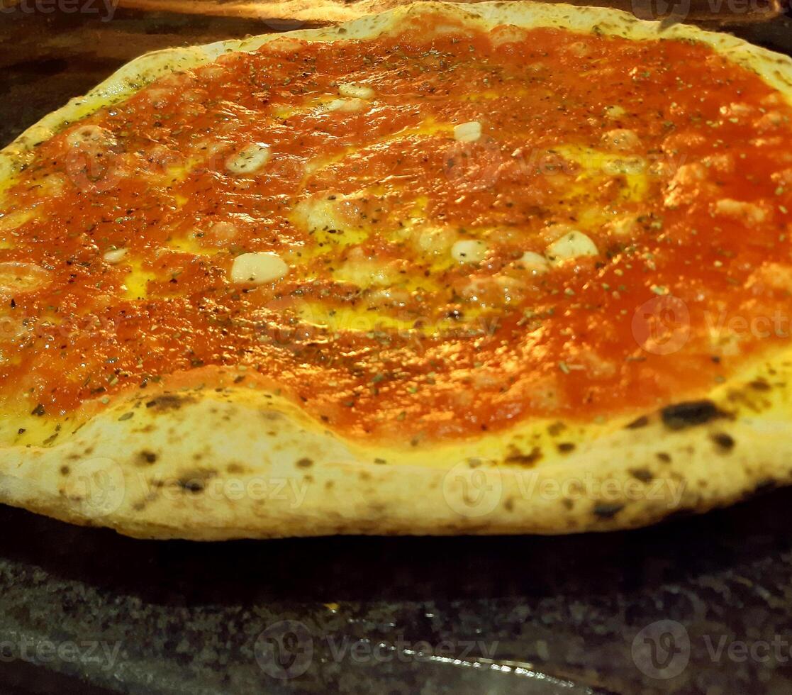 pizza tasty hot pepperoni covered slices cooking ingredients tomatoes with prosciutto and red tomato spices on table. photo