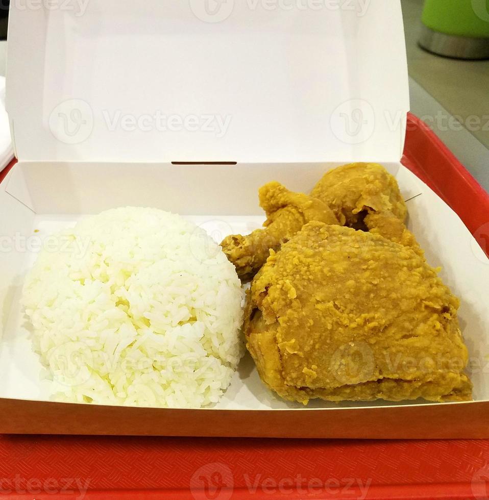 Fresh delicious crispy fried chicken golden brown with white rice on white box. photo