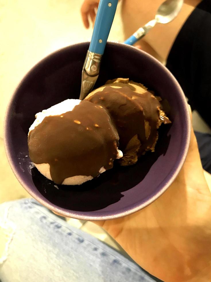 helado sabor verde patrón de postre congelado en taza negra mano sujetando la madera. foto