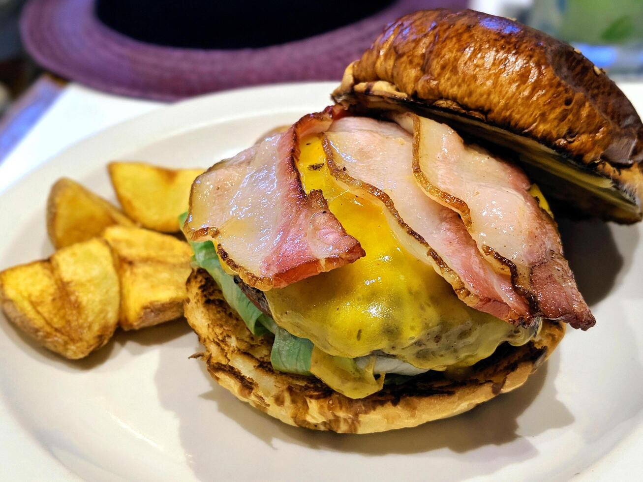 Fresh Street food beef burger with brown bread,vegetables, egg, bacon, cheese and sauces. photo