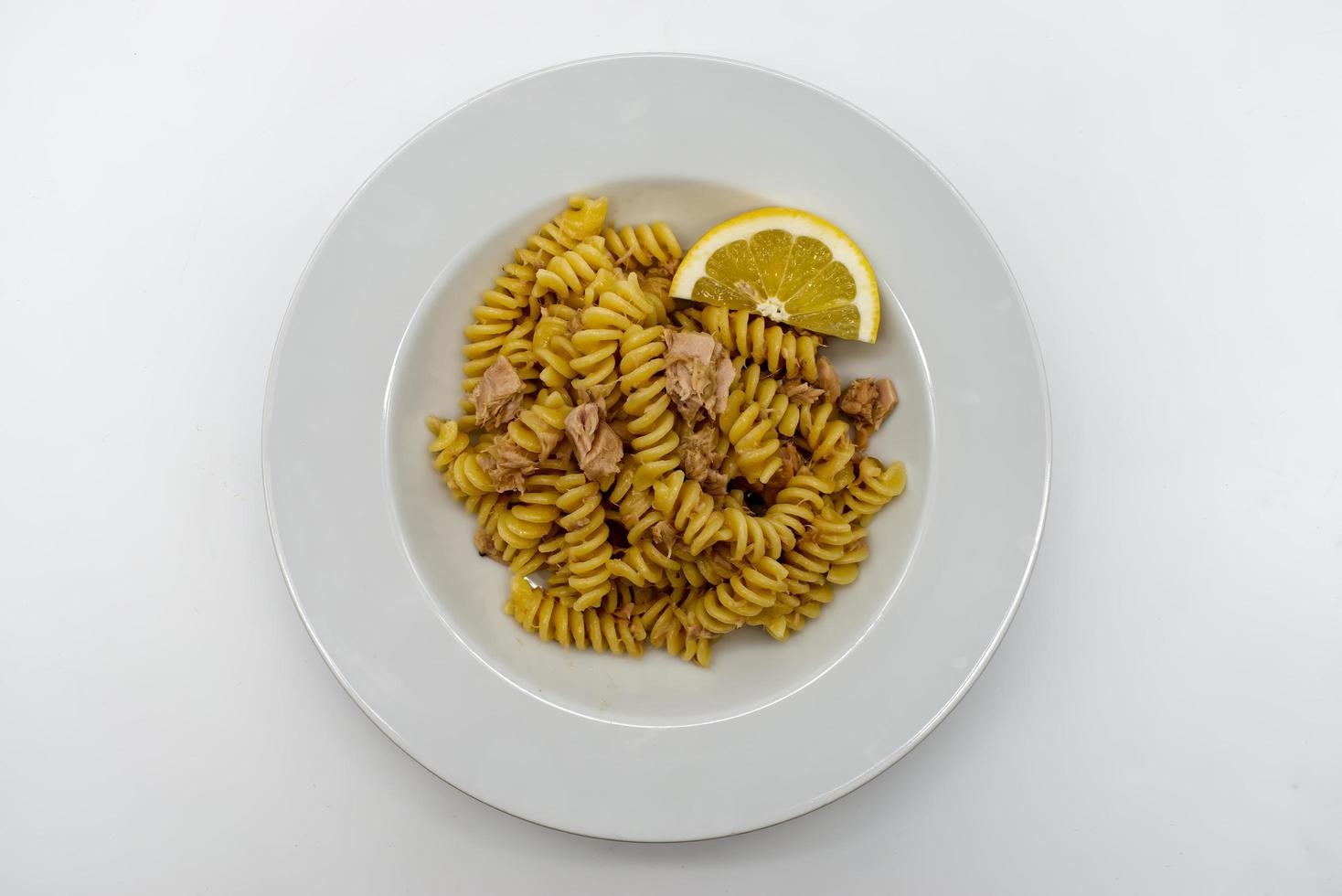 Italian Fusilli Pasta with tuna and lemon in a white dish photo
