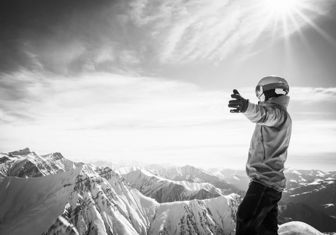 Background image of male person in ski suit with hands wide open enjoying panorama of snowy mountains photo