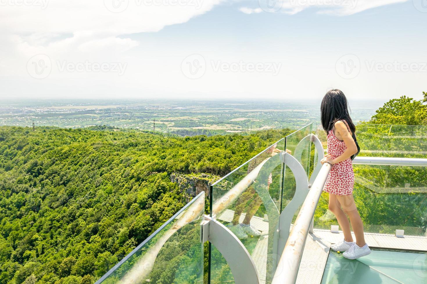 Attractive female person stands on Sataplia viewpoint ad enjoys stunning green forest panorama. photo