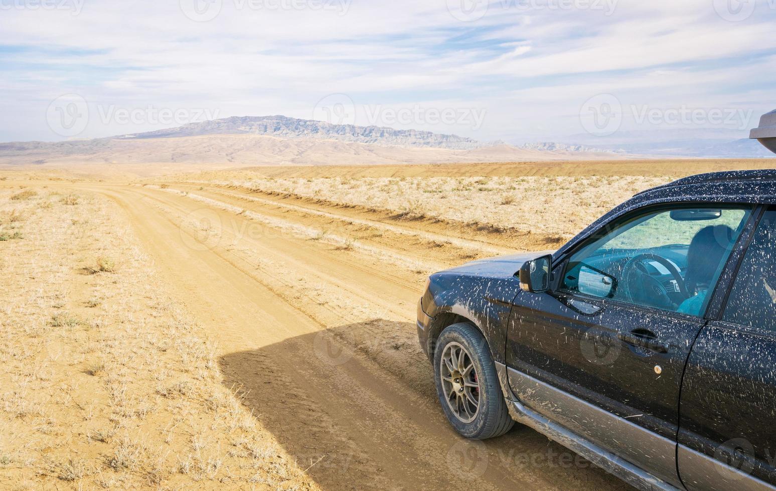 Car stands on the gravel road in deserted area in Vashlovani national park. Extreme travel in caucasus photo