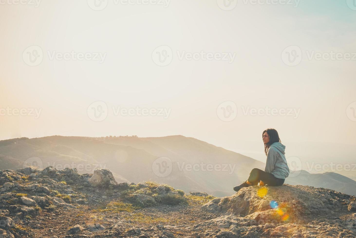 Rear view image of a woman sitting alone on peak mountain looking left  blank space bright background 4871315 Stock Photo at Vecteezy