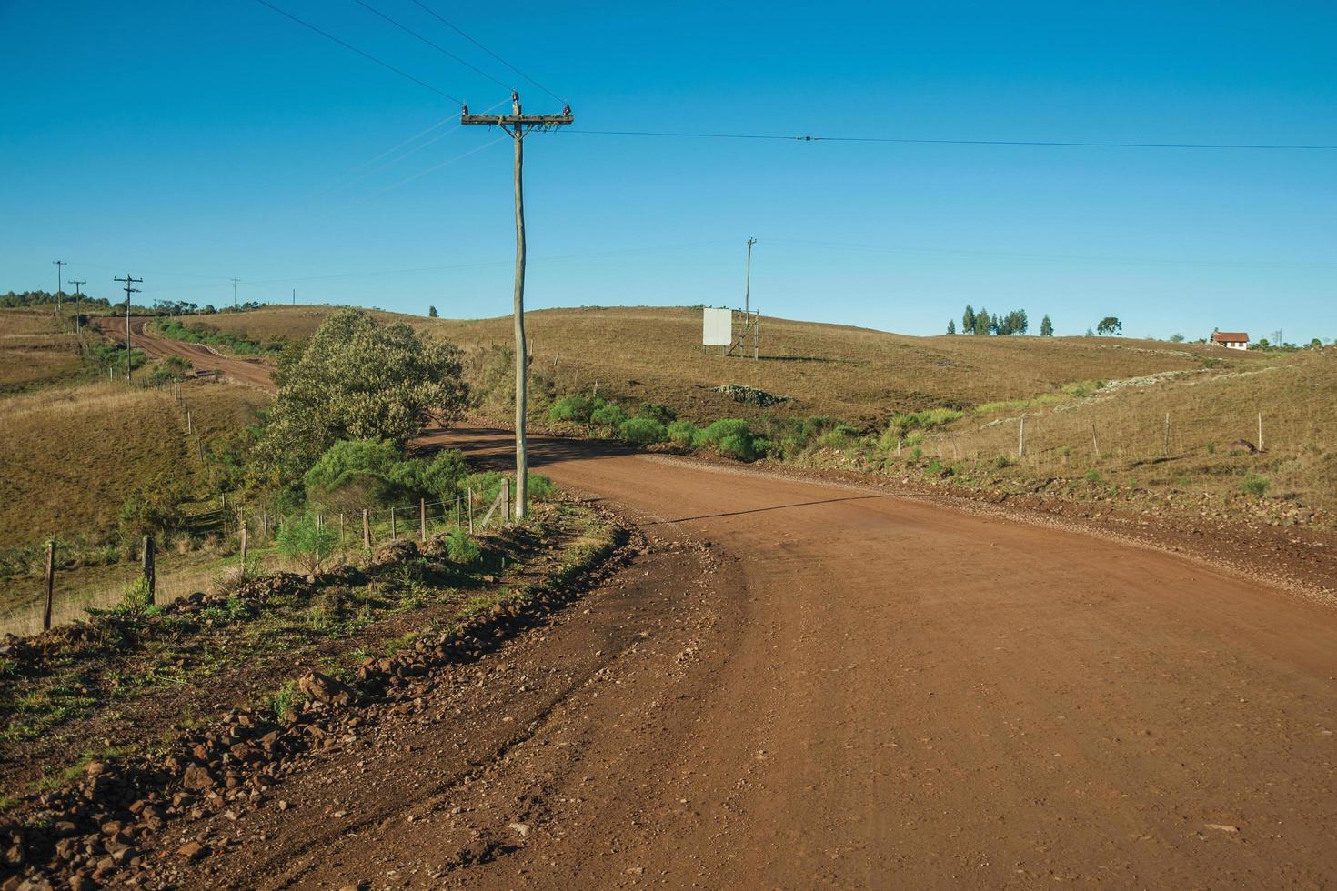 Deserted dirt road passing through rural lowlands called Pampas with green hills and trees near Cambara do Sul. A small country town in southern Brazil with amazing natural tourist attractions. photo