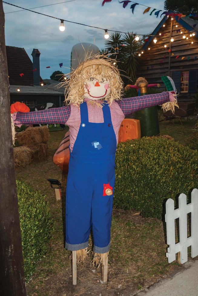 Scarecrow made of colorful clothes in a garden at dusk from a folkloric festival in Canela. A charming small town very popular by its ecotourism in southern Brazil. photo