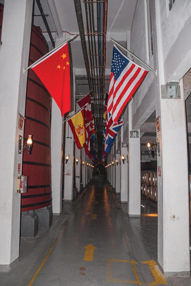 Corridor with tanks for wine storage and flags from several countries at the Aurora Winery facilities in Bento Goncalves. A friendly country town in southern Brazil famous for its wine production. photo