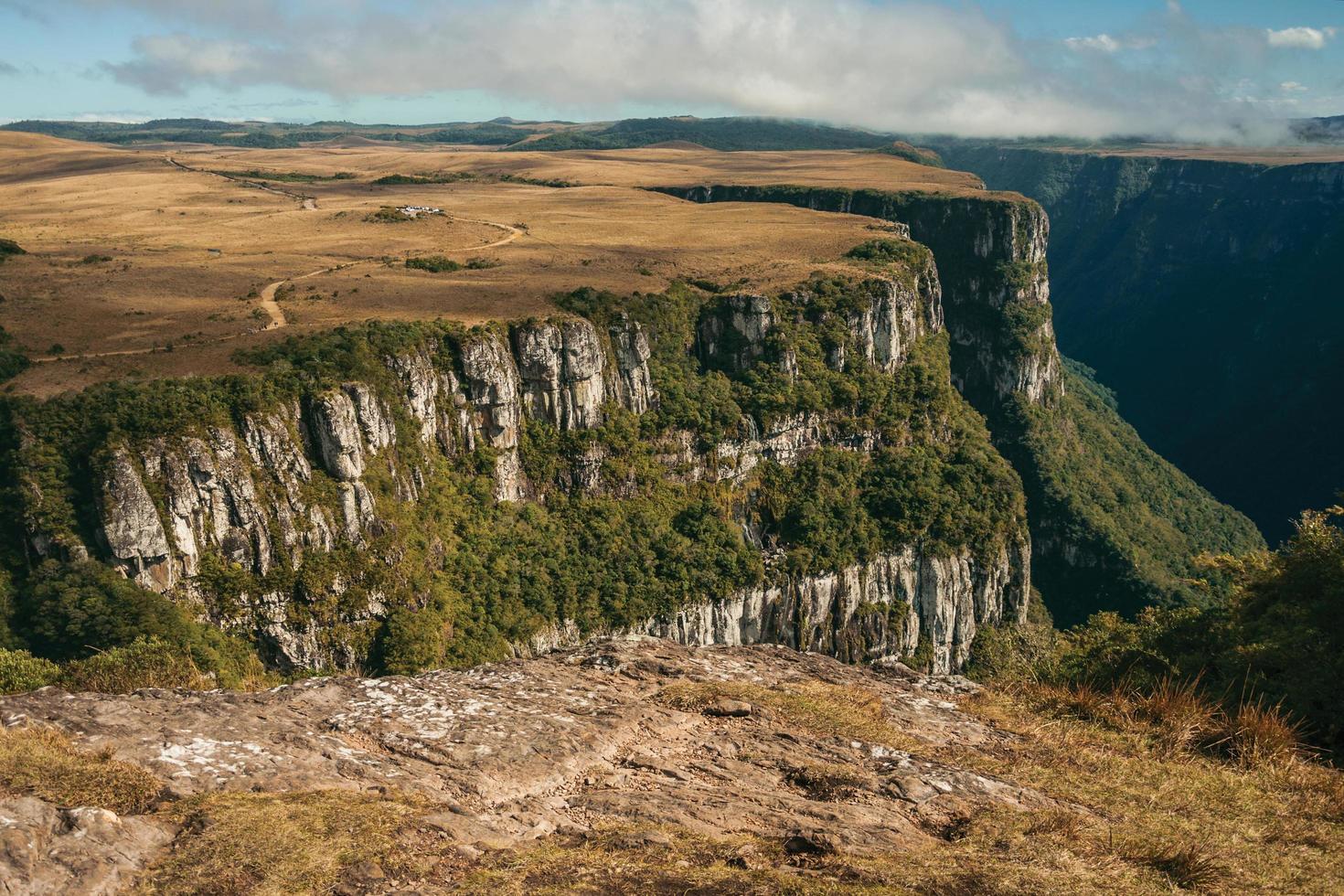 Fortaleza Canyon shaped by steep rocky cliffs with forest and flat plateau covered by dry bushes near Cambara do Sul. A small country town in southern Brazil with amazing natural tourist attractions. photo