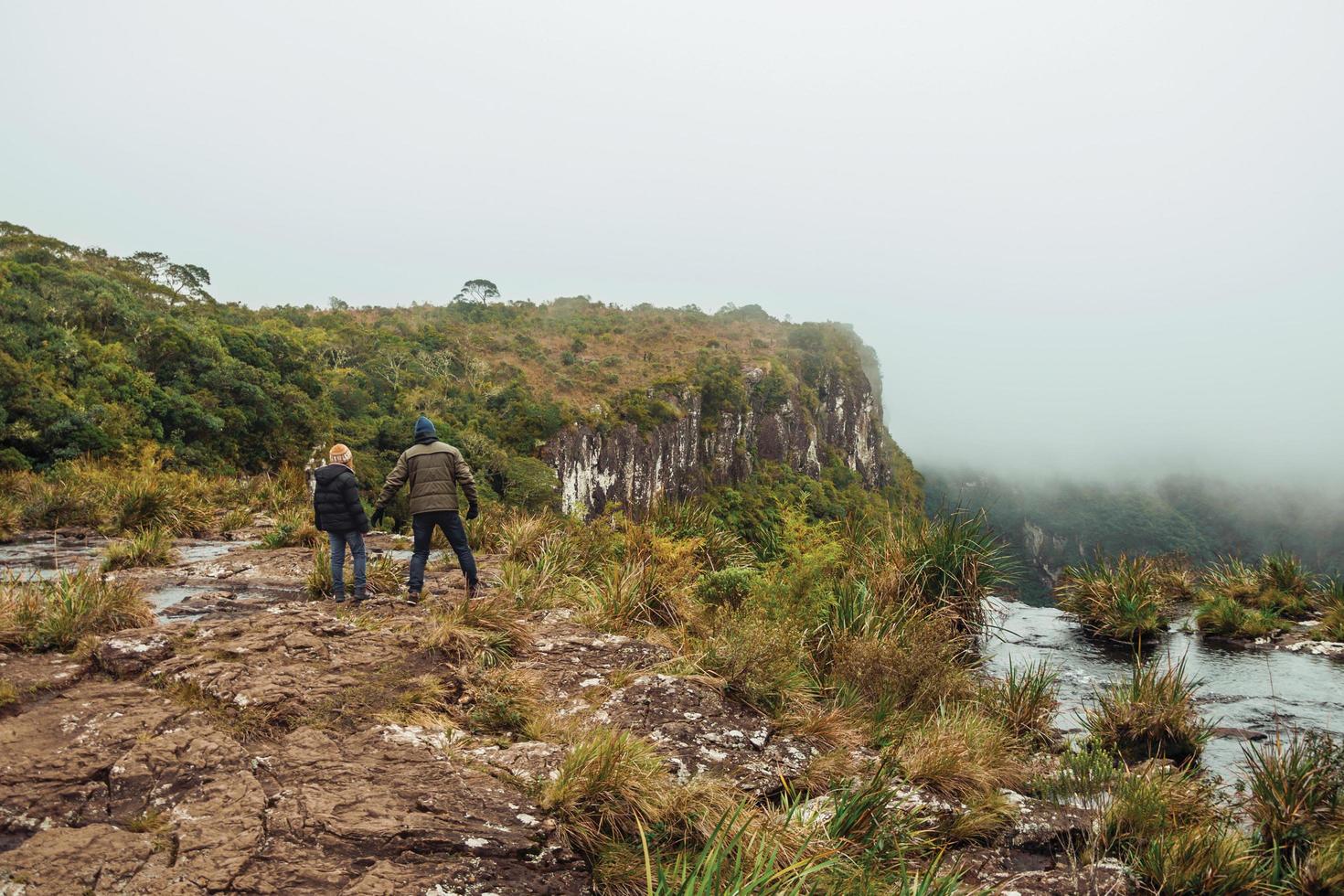 la gente en el borde del acantilado y la niebla que viene del valle verde en el parque nacional de la serra geral, cerca de cambara do sul. un pequeño pueblo rural en el sur de Brasil con increíbles atractivos turísticos naturales. foto