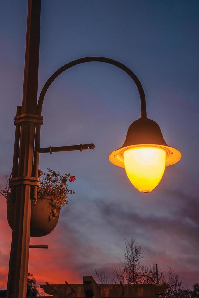 Detail of a decorative light post and colorful sky at sunset in Gramado. A cute european-influenced town in southern Brazil, highly sought after by tourists. photo